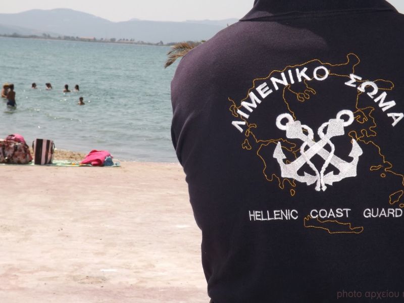 Εικόνα που δείχνει την πλάτη ατόμου-μέλους, που φορά μπλούζα από το λιμενικό σώμα.